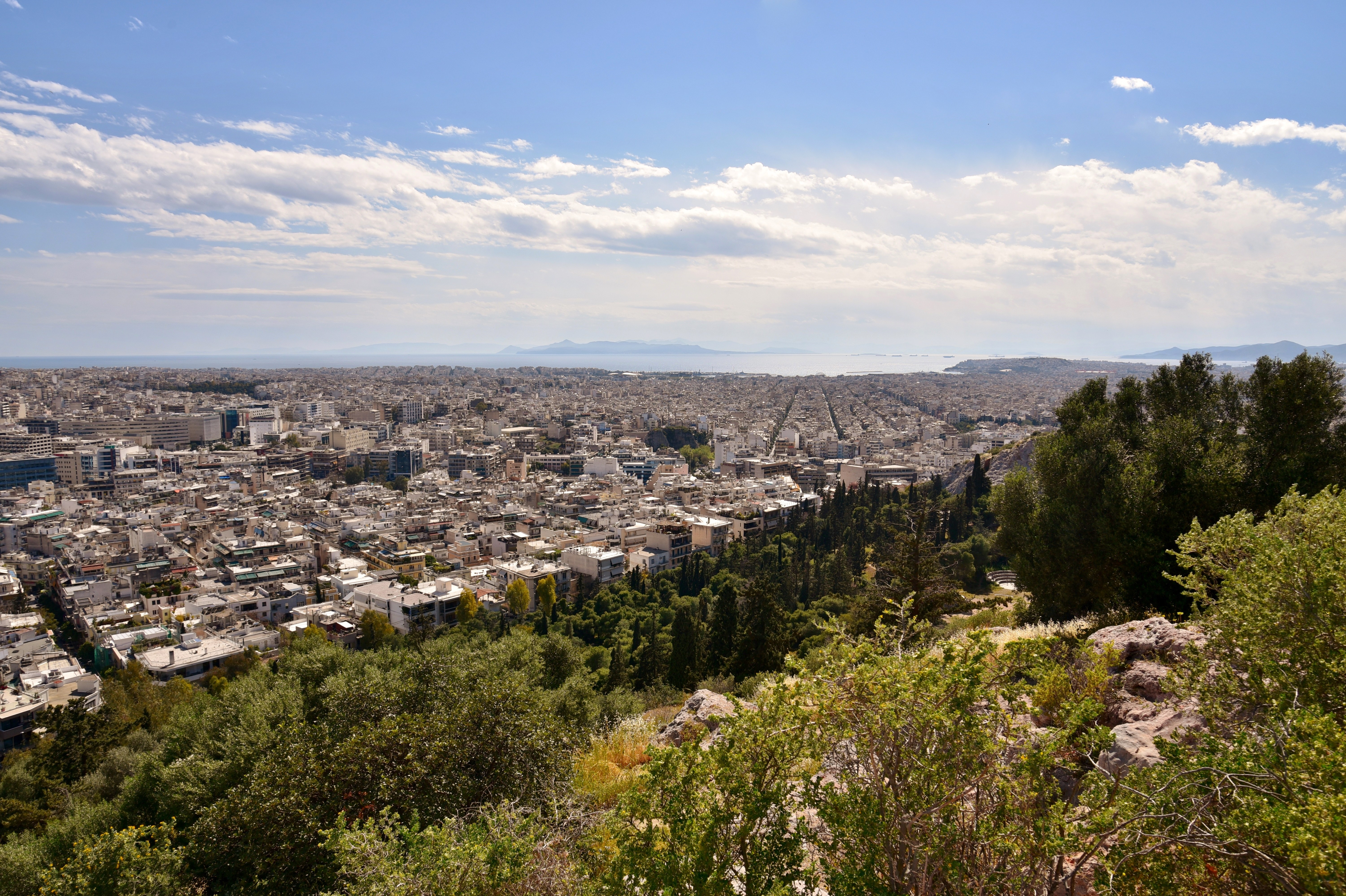 Πανοραμική άποψη κτιρίων προς την Καλλιθέα και τη θάλασσα, με βράχια και πράσινο στο προσκήνιο, σε φωτογραφία αρχείου του 2019.