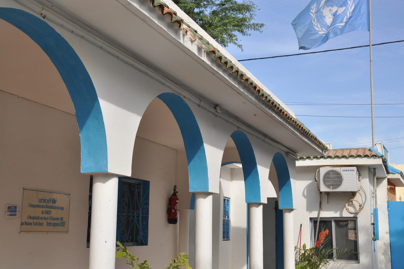 Γραφείο της UNICEF στη Νουακσότ με λευκούς τοίχους, γαλάζιες αψίδες και σημαία ΟΗΕ· αρχείο 2009, όχι η καμπάνια του 2026.