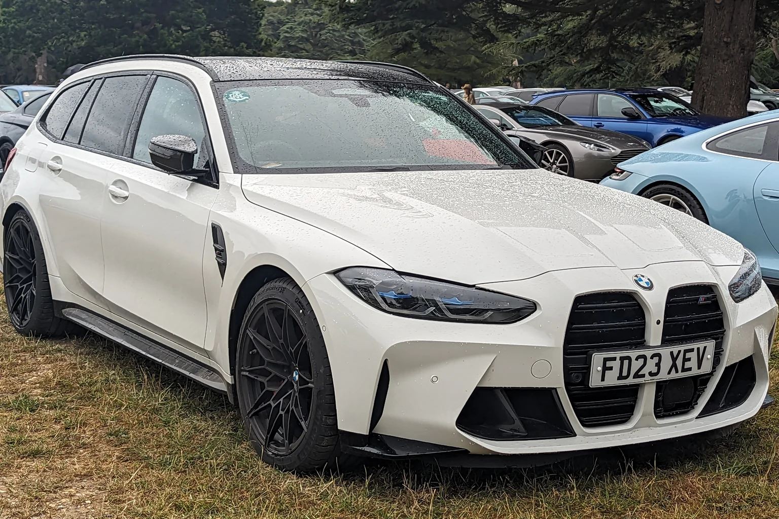 Λευκή BMW M3 Touring σε χώρο στάθμευσης με δέντρα — φωτογραφία αρχείου του 2023.