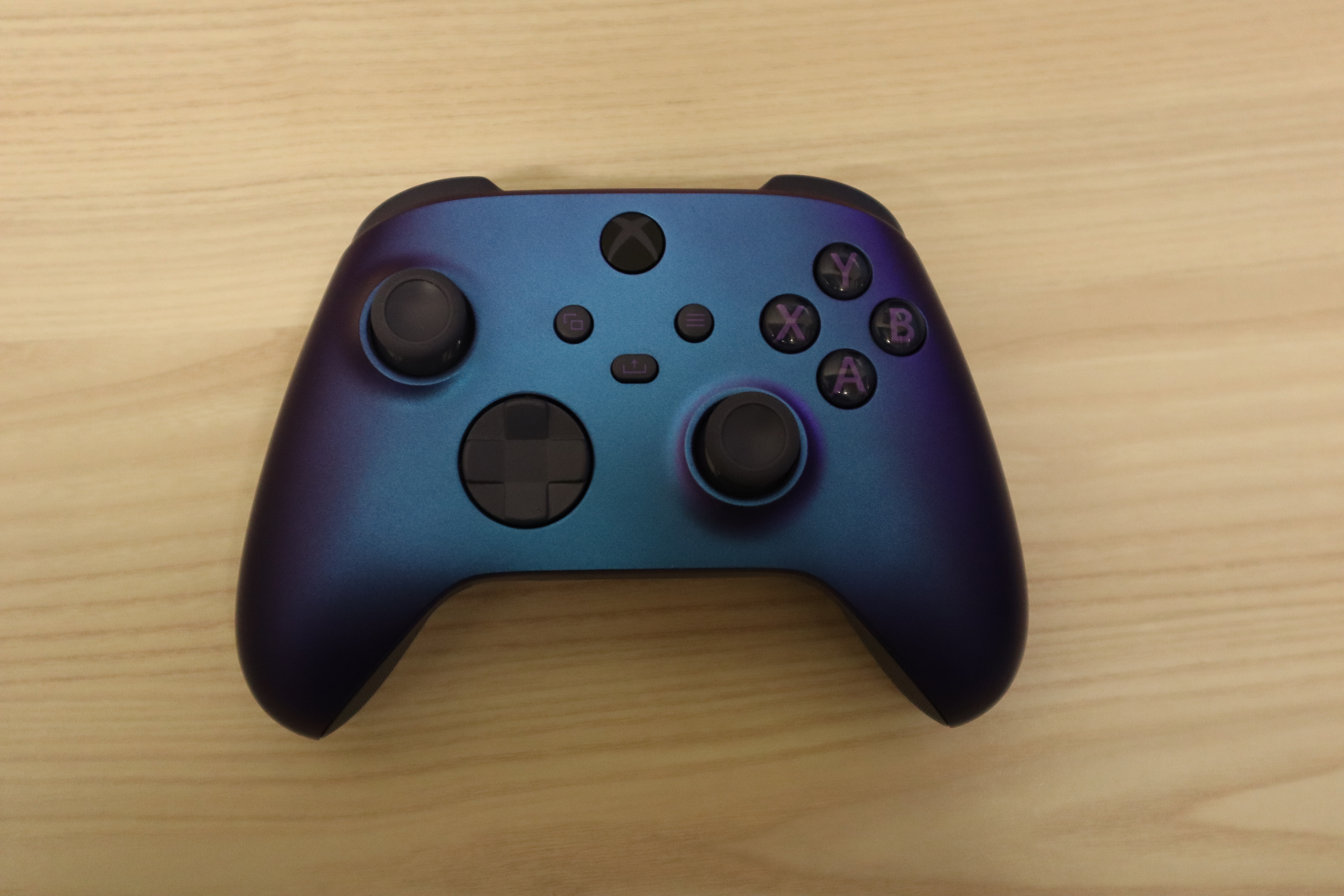 Μπλε-μοβ χειριστήριο Xbox Wireless Controller Stellar Shift πάνω σε ξύλινη επιφάνεια· φωτογραφία αρχείου 2023, όχι σκηνή του Echo Weaver.
