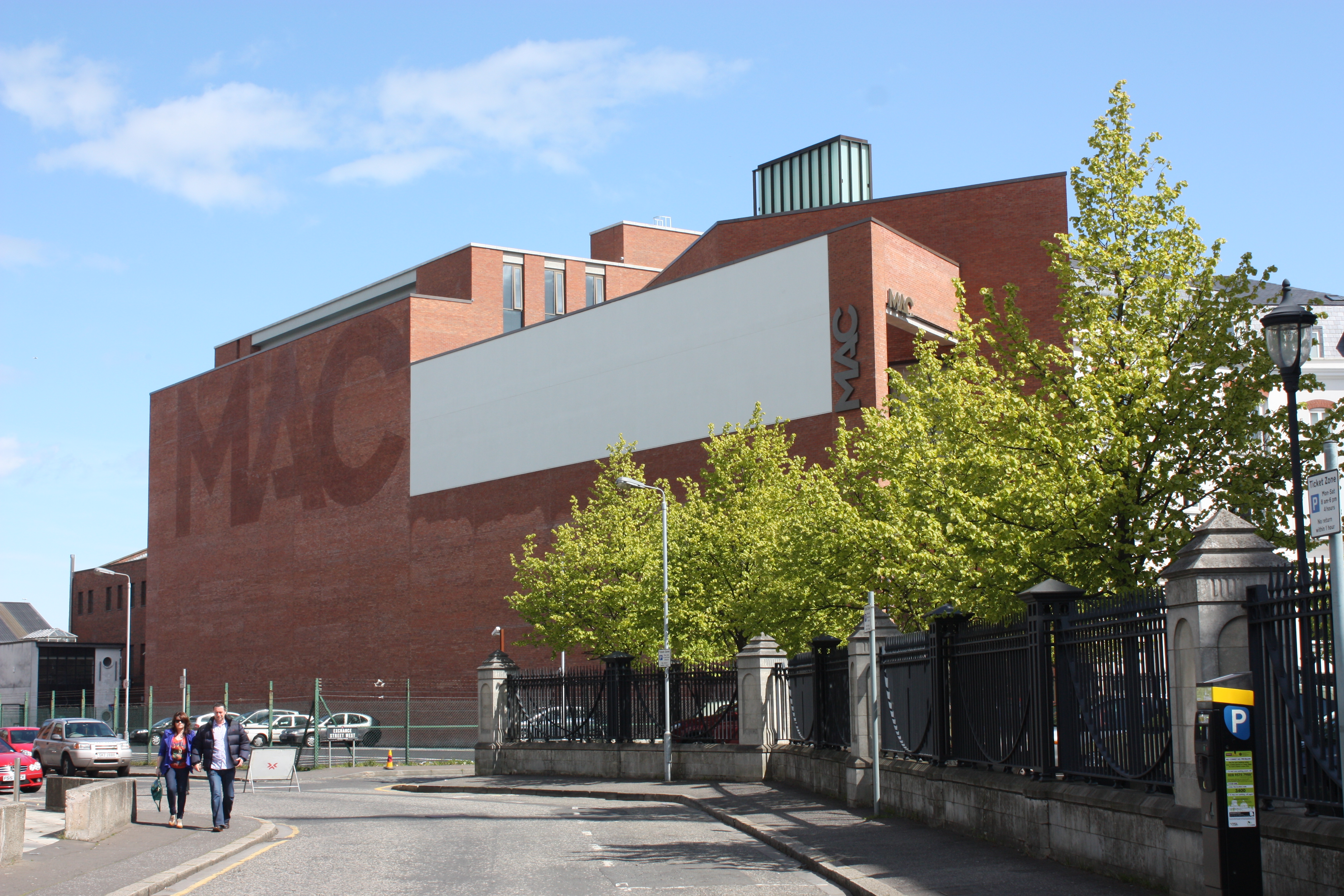 Αρχειακή εξωτερική άποψη του MAC στο Belfast, με το κτίριο, δέντρα και δρόμο.